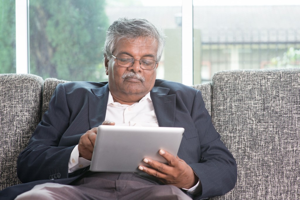 Older man on tablet reading