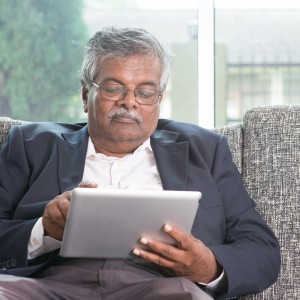 Older man on tablet reading