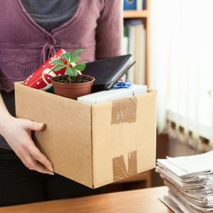 Woman holds box full of desk contents